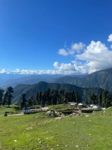 Majestic mountain view in Uttarakhand with lush greenery under a clear blue sky.